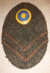 Mössmärke m/40 (1942-45) mössoval i tyg 50x75 mm med nationalitetsmärke m/41, gradbeteckning galon i bronsfärg fastsydd i vinklar till uniform m/39 fält- och permissionsmössa och vintermössa m/43